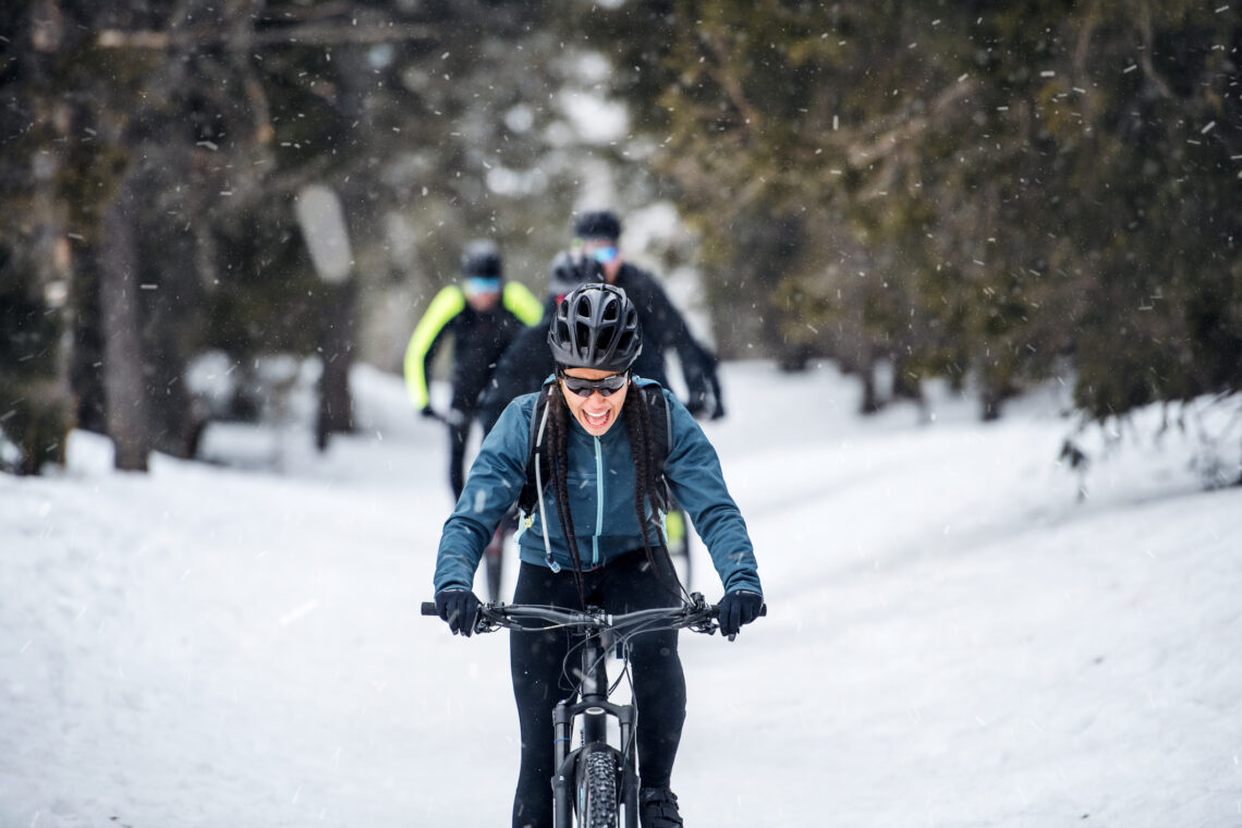 Žena biciklira po snijegu